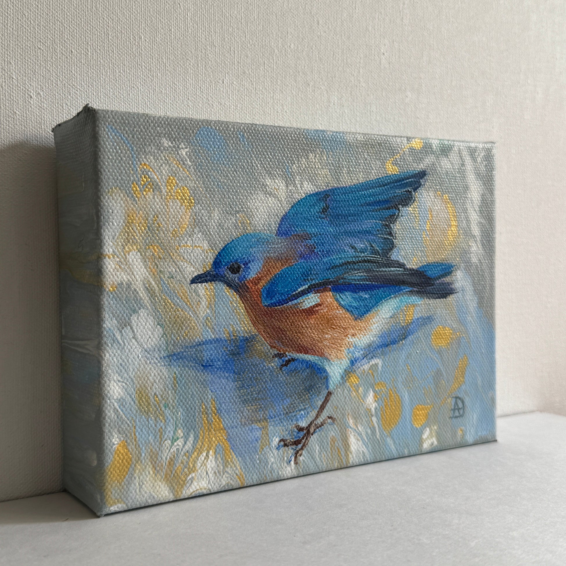 Painted canvas with a blue bird on a light gray background